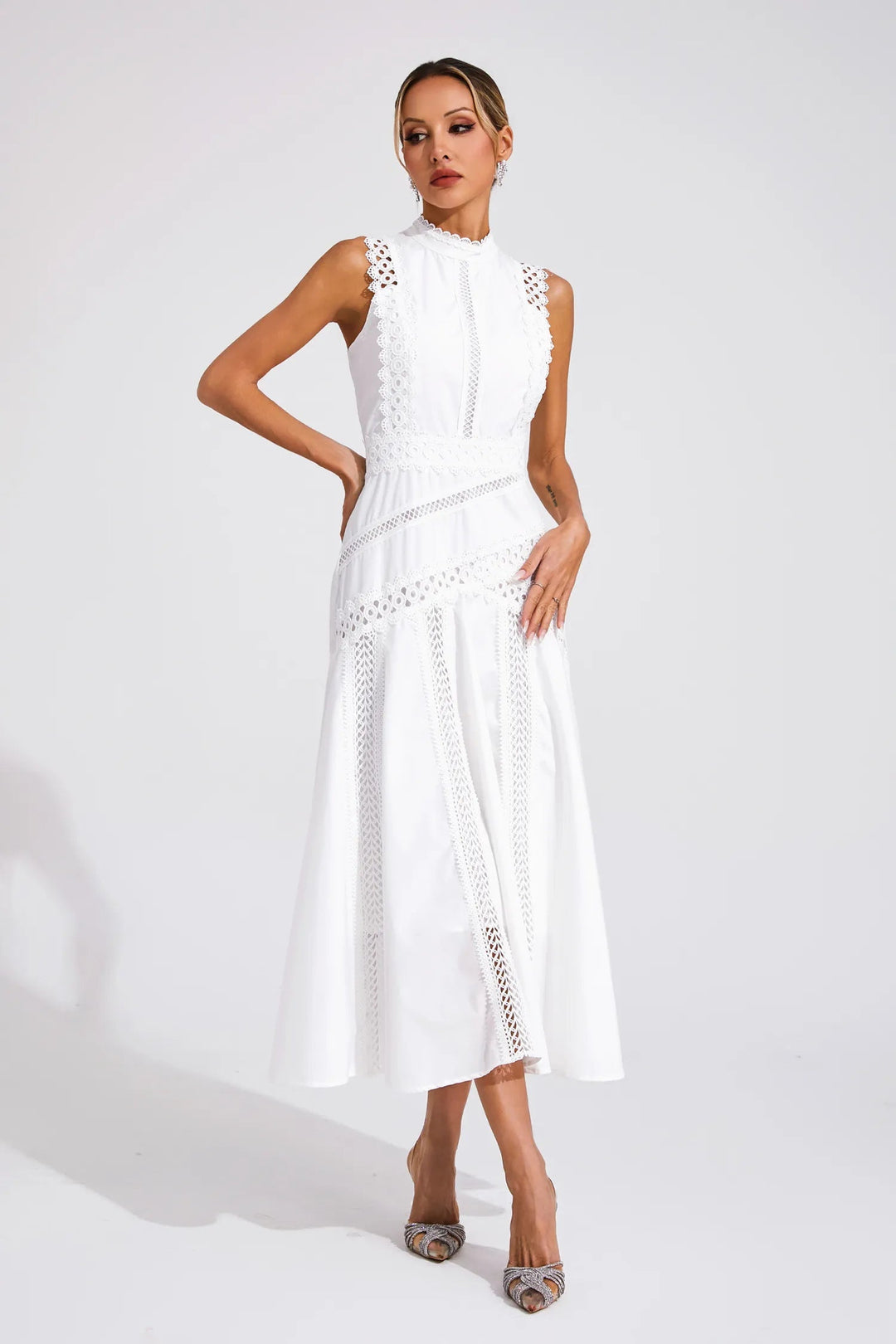 Female in a softly flared midi dress with a structured upper shape on a plain background.