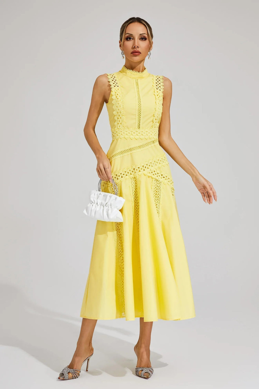 Female wearing a sleeveless dress with a defined waist and flared skirt on a plain background.