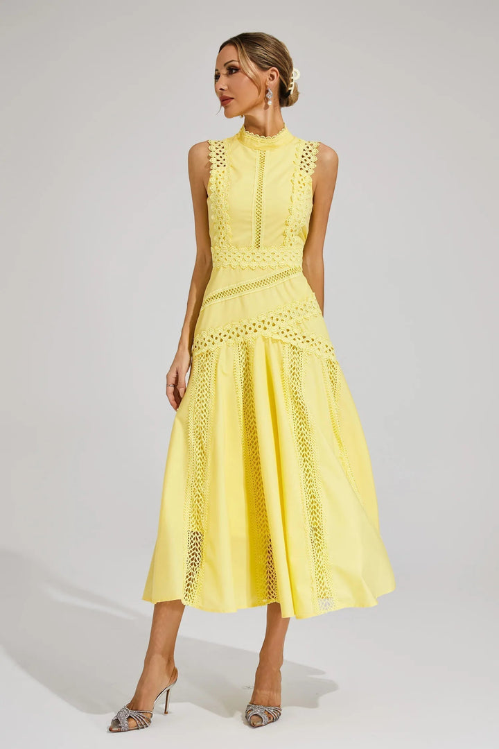 Woman in a refined midi dress with decorative accents on a plain background.
