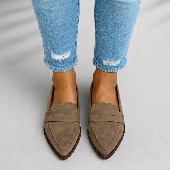 Woman in pointed toe loafers styled for everyday outfits on a plain background.