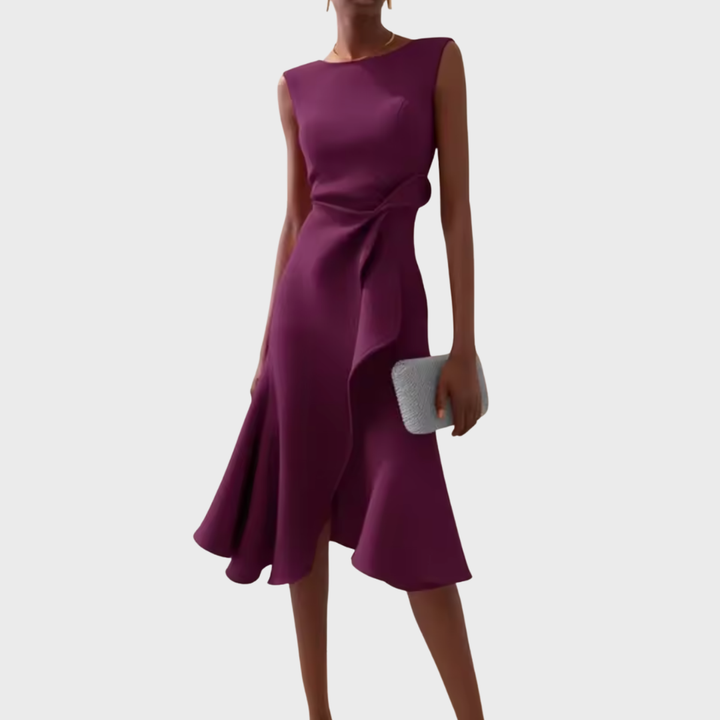 Female model in a printed V-neck midi dress with an A-line shape on a plain background.