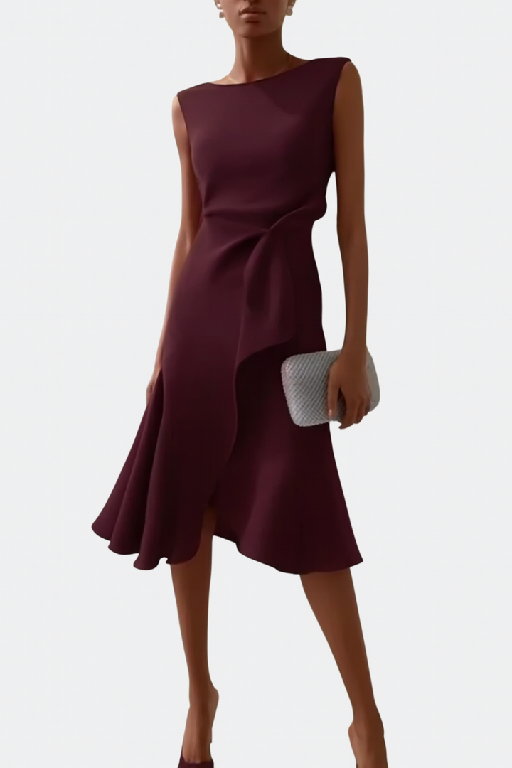 Woman wearing a midi-length printed dress for daily styling on a plain background.