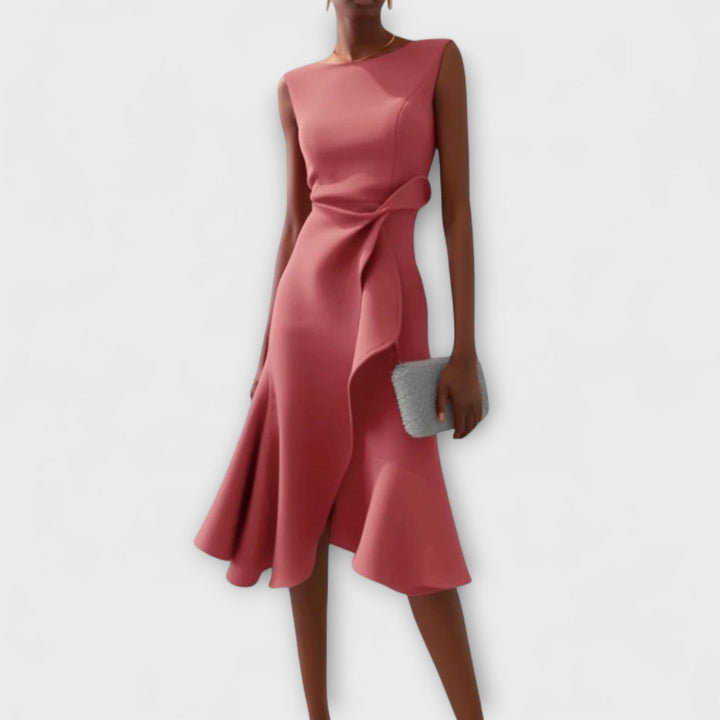 Female model showcasing an A-line printed midi dress with pockets on a plain background.