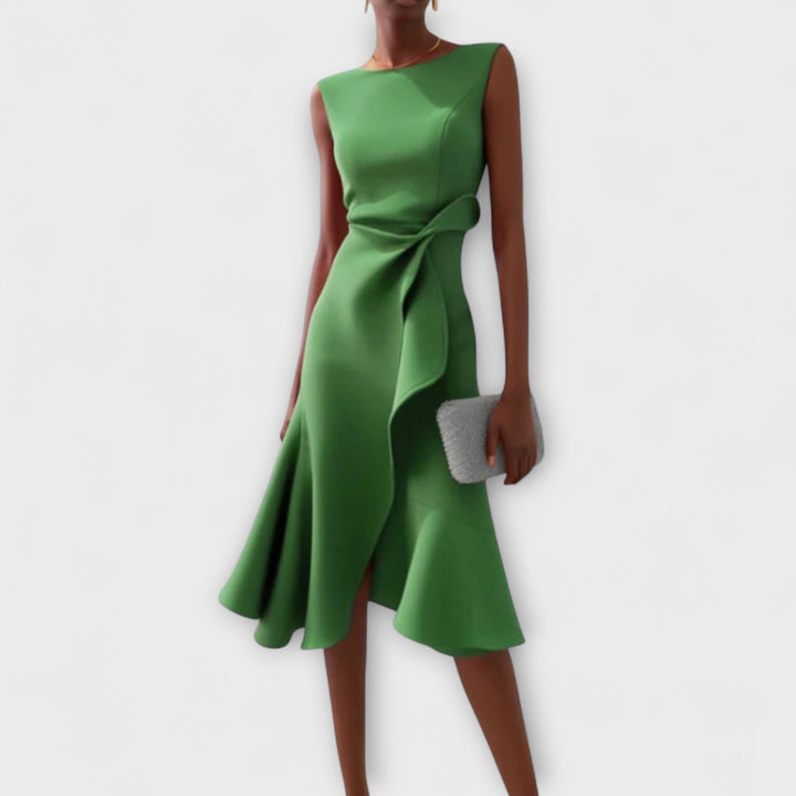 Woman wearing a printed midi dress on a plain background.