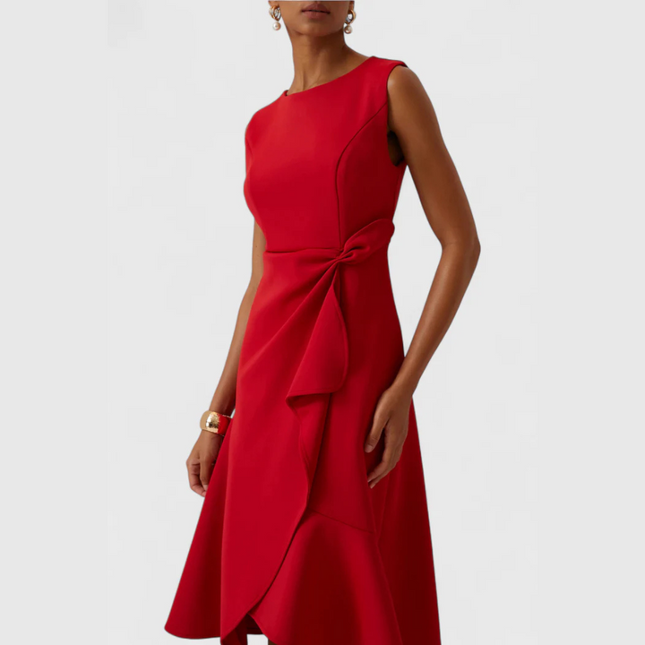 Female model in a printed casual dress with a neat V-neckline on a plain background