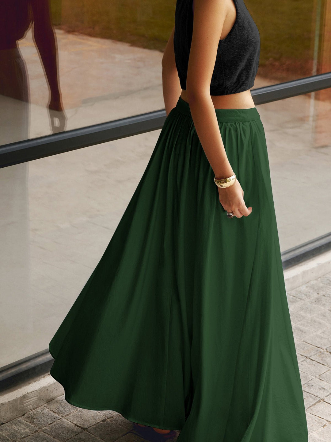 Female model wearing a long A-line skirt with a clean waistline on a plain background.