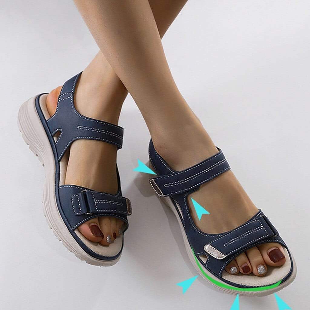 Woman wearing cushioned strap sandals against a plain background.