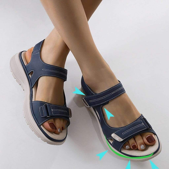 Woman wearing cushioned strap sandals against a plain background.