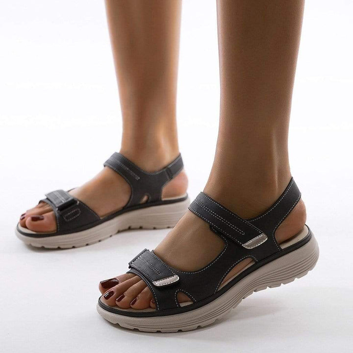 Model wearing adjustable walking sandals on a plain background.