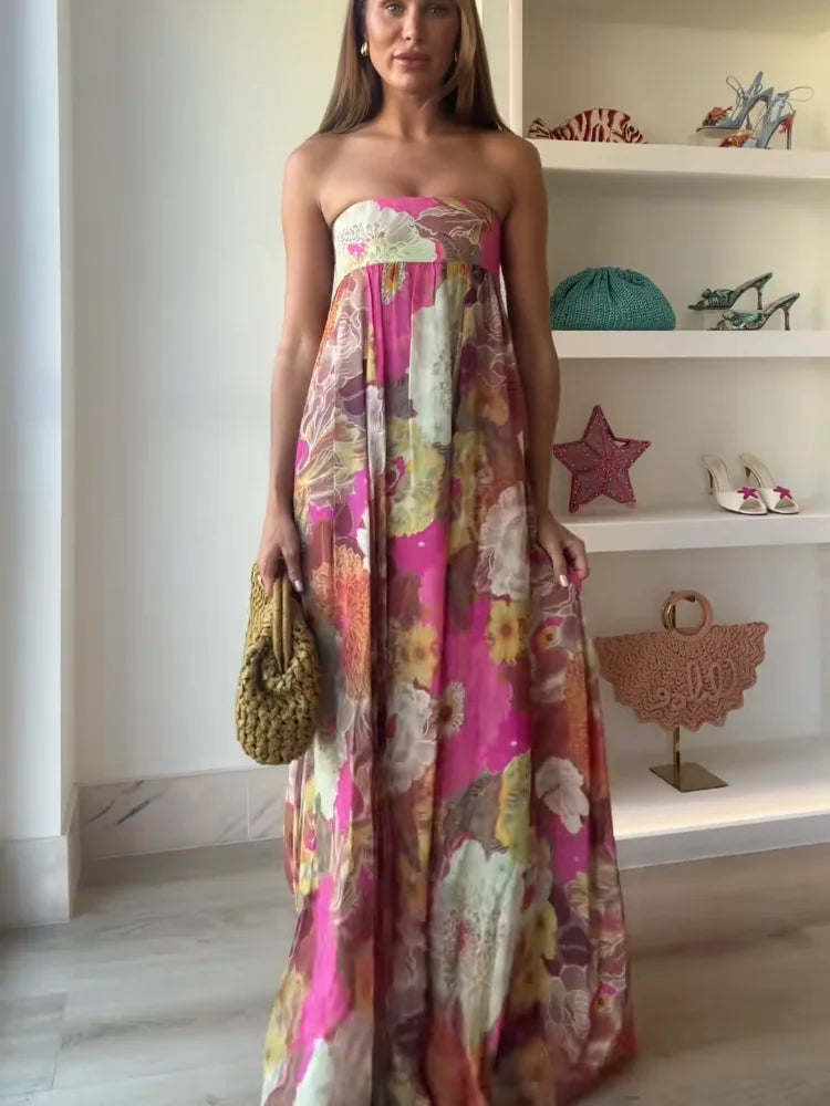  Female displaying a strapless floral dress with a graceful full-length design on a plain background