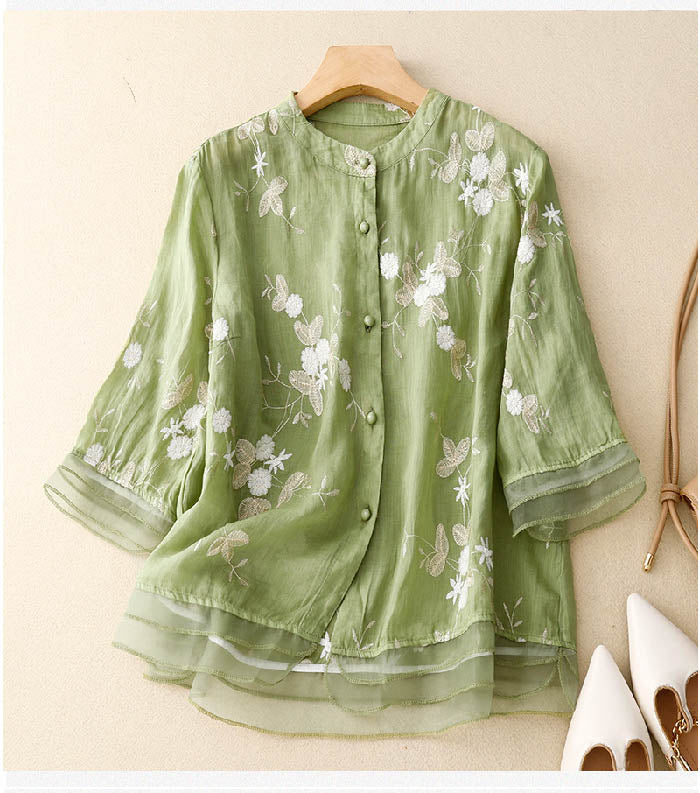 A floral embroidered blouse against a plain background.