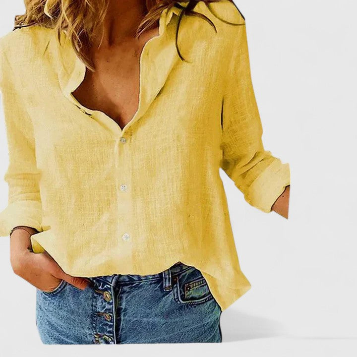 Female wearing a collared button-down shirt with a relaxed silhouette.
