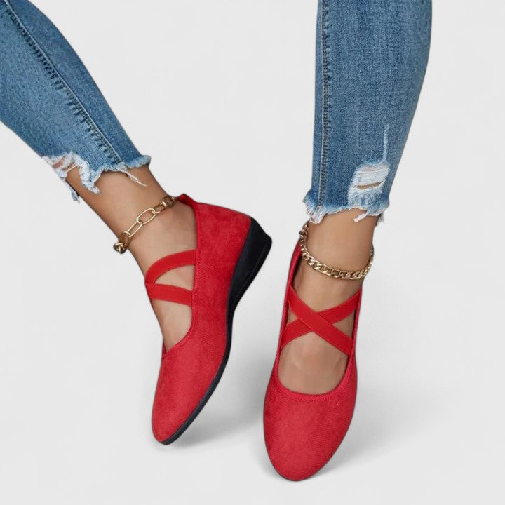 Female wearing flat Mary Jane shoes with a classic outfit on a plain background.